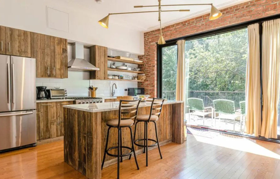 Ao usar a madeira de diferentes formas, esta cozinha ganhou um ar rústico