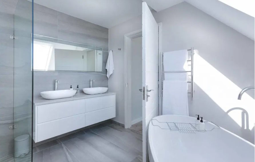 Nesta inspiração de banheiro com decoração minimalista o uso da cor branca ajuda a reforçar o aspecto de leveza do ambiente.
