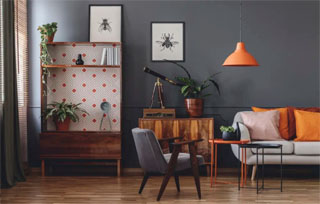 Essa sala de estar no estilo vintage misturou tons escuros com um laranja, dando uma personalidade a mais ao ambiente